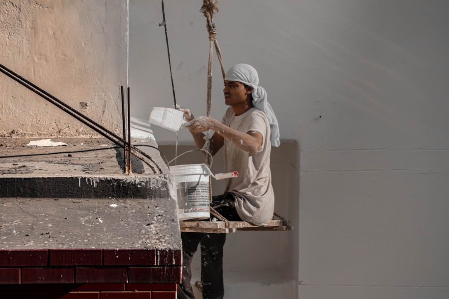 Indian worker painting an exterior wall